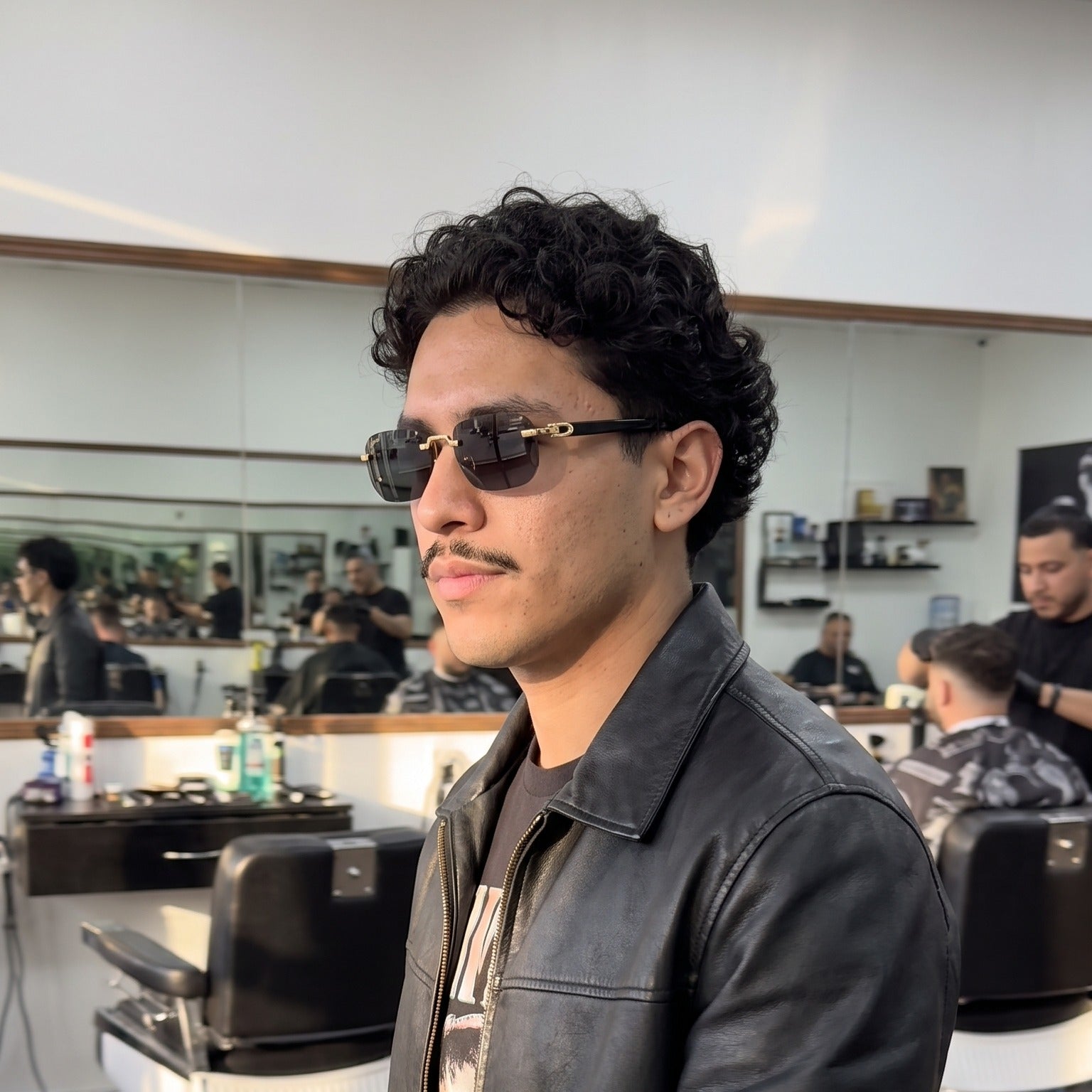 Man wearing the Rimless buffs Sunglasses, solid grey lenses, Cartier eyewear